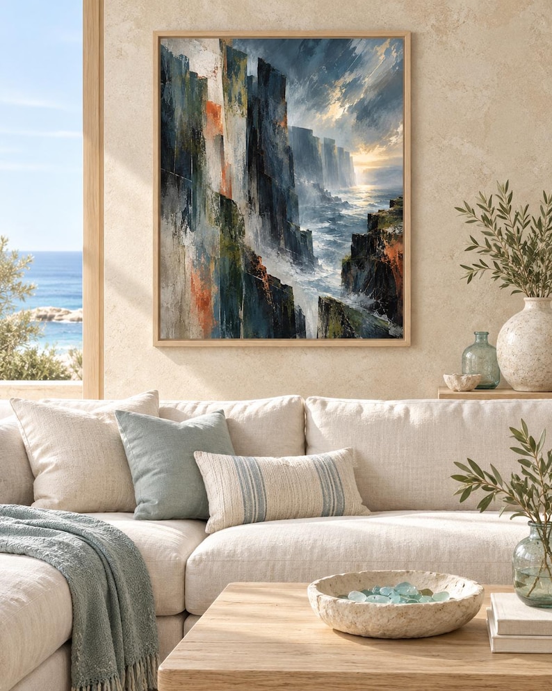 May include: A framed wall art print depicting a dramatic coastal landscape with steep, dark cliffs, crashing ocean waves, and a bright horizon. The painting features a palette of deep blues, grays, and earthy orange tones with visible brushstrokes.