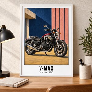 May include: A framed wall art print featuring a 1985 Yamaha V-Max motorcycle in red and black. The motorcycle is parked on a yellow surface against a blue and pink architectural background. The text V-MAX Yamaha 1985 is printed at the bottom.