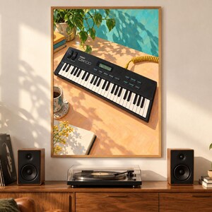 Puede incluir: Una impresi&oacute;n de arte mural enmarcada que muestra un sintetizador Yamaha DX100 negro sobre una superficie clara. La escena incluye una planta en maceta, una taza y un cuaderno, iluminados por la luz del sol que proyecta sombras.