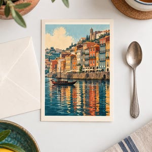 May include: A rectangular art print featuring a coastal town with colorful buildings in shades of orange, yellow, and blue, situated along a stone embankment. A small wooden boat floats on the water, which reflects the vibrant architecture.