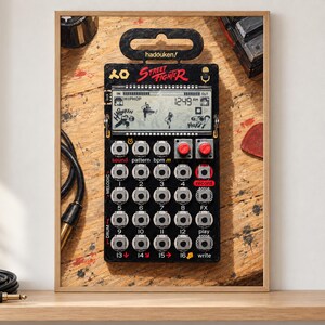 May include: A black pocket synthesiser featuring a Street Fighter theme with a digital display showing game characters, multiple circular buttons, two red knobs, and the text hadouken, Street Fighter, sound, pattern, bpm, record, melodic, drum, play, and write.