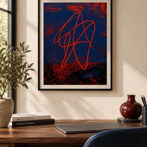 May include: A framed wall art print featuring a dark blue and black textured background with a prominent, bright red continuous line drawing that forms an abstract, tangled shape centered within the composition, enclosed in a thin black frame.