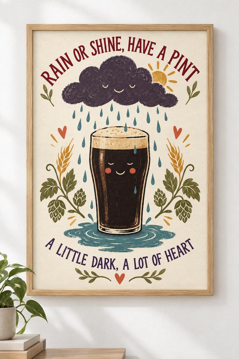 May include: A framed wall art print featuring a dark beer pint with a smiling face, surrounded by rain, a sun, and hops. The text reads: RAIN OR SHINE, HAVE A PINT and A LITTLE DARK, A LOT OF HEART. The illustration uses a cream background with red, blue, and green.