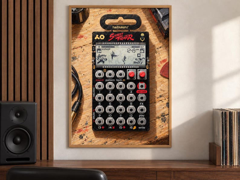 May include: A black Street Fighter themed pocket synthesiser featuring a digital display with game graphics, sixteen numbered buttons, two red knobs, and the text hadouken/ printed at the top. The device has a grid layout for sound, pattern, and drum controls.