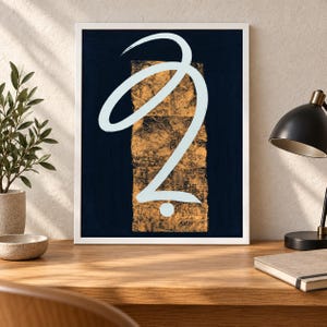 May include: A framed wall art print featuring a dark navy blue background with a central vertical rectangular panel of textured gold leaf. Overlaid on the gold and navy is a single, fluid, light blue brushstroke line forming a calligraphic shape.