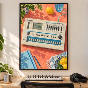 May include: A framed print featuring a Roland TR-727 Rhythm Composer drum machine on a vibrant orange surface. The scene includes a lemon, a blue glass of water, a blue notebook with a pen, and a bowl with lemons, all under bright sunlight.