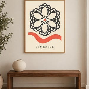 K&ouml;nnte beinhalten: Ein gerahmter Wandkunstdruck mit cremefarbenem Hintergrund, einem dunkelgrauen geometrischen Blumenmuster &uuml;ber einer horizontalen roten Wellenlinie. Das Wort LIMERICK ist in dunkelgrauen Gro&szlig;buchstaben unten auf dem Bild gedruckt.
