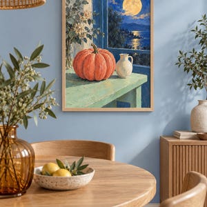 Pode incluir: Uma impress&atilde;o de arte de parede emoldurada retratando uma ab&oacute;bora laranja vibrante e um pequeno jarro branco sobre uma mesa verde clara. A cena situa-se diante de uma janela aberta com vista para um mar azul escuro sob uma lua cheia.
