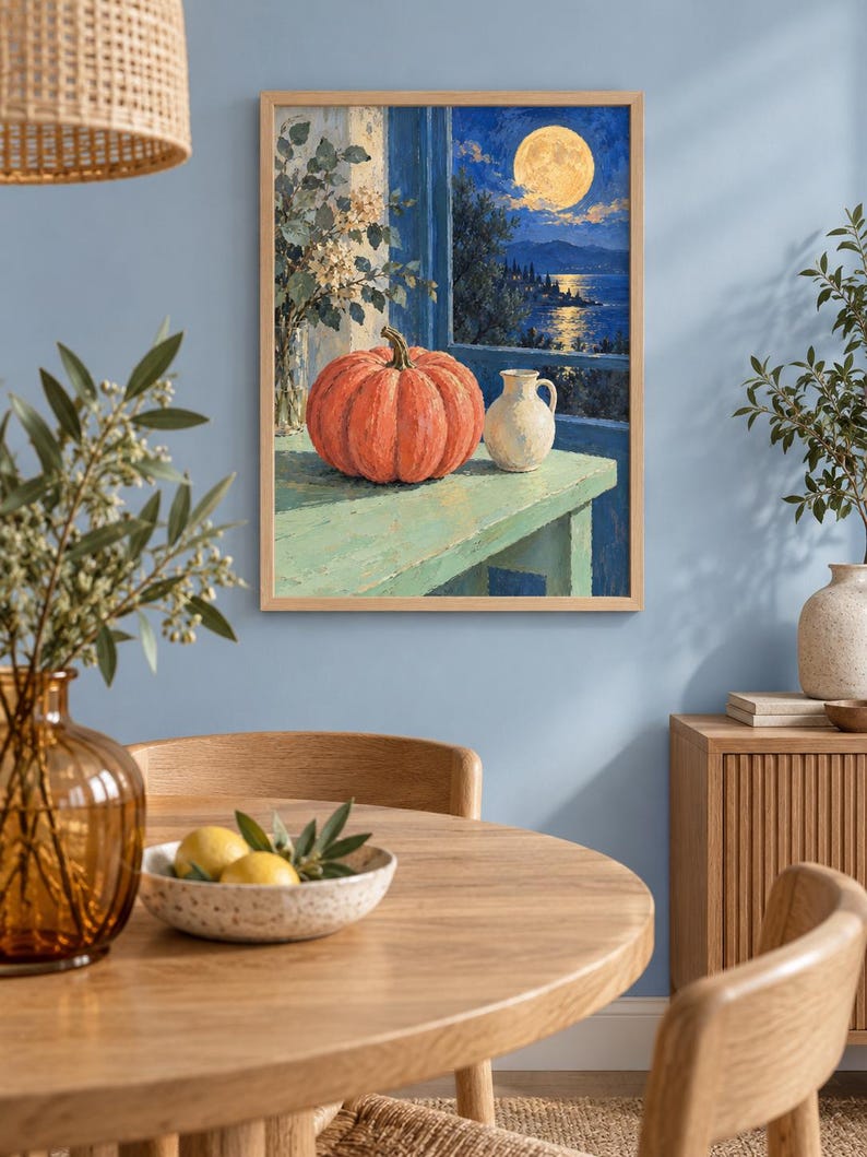 Pode incluir: Uma impress&atilde;o de arte de parede emoldurada retratando uma ab&oacute;bora laranja vibrante e um pequeno jarro branco sobre uma mesa verde clara. A cena situa-se diante de uma janela aberta com vista para um mar azul escuro sob uma lua cheia.