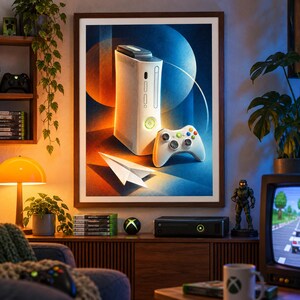May include: A framed wall art print featuring a white video game console and a matching white wireless controller, accompanied by a white paper airplane, set against a vibrant blue and orange abstract background with circular shapes.