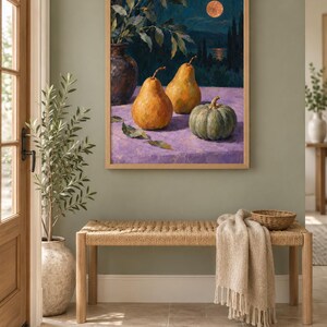 May include: A framed oil painting depicting two golden pears and a green pumpkin on a purple surface. The background shows a dark night landscape with a full moon, a body of water, and silhouettes of trees. The painting is enclosed in a light wood frame.