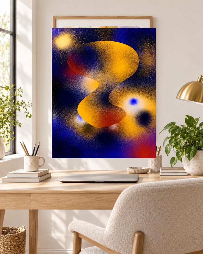 May include: A rectangular wall art print featuring an abstract composition with a central, fluid, golden-yellow organic shape set against a deep blue background. The design incorporates spray-painted textures, speckles, and vibrant orange and red accents.