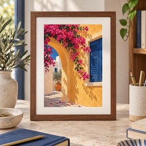 May include: A framed wall art print depicting a Mediterranean scene with a yellow stucco wall, a bright blue shuttered window, and vibrant pink bougainvillea flowers cascading over a stone archway under a clear blue sky.