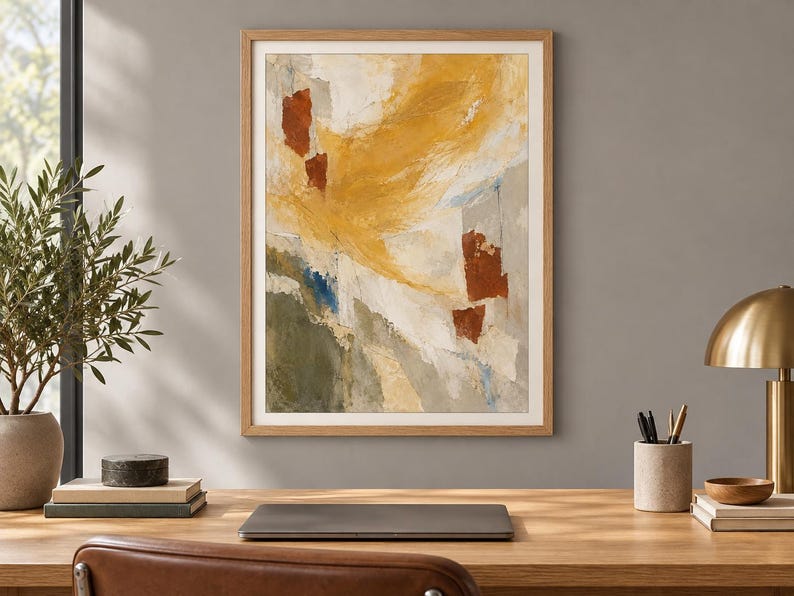 May include: A framed abstract wall art print featuring a textured composition of mustard yellow, burnt orange, olive green, and white paint strokes. The artwork is enclosed in a light-toned wooden frame with a white mat border, displayed on a wall.
