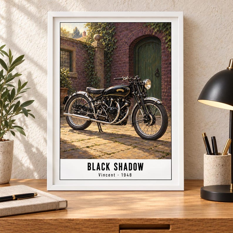 Peut inclure: Une impression d'art encadr&eacute;e repr&eacute;sentant une moto Vincent Black Shadow noire de 1948 gar&eacute;e sur une terrasse en pierre devant un b&acirc;timent en briques avec une porte verte. Le texte en bas de l'impression indique BLACK SHADOW Vincent 1948.