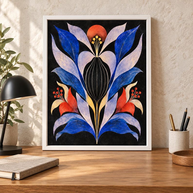 May include: A framed wall art print featuring a symmetrical botanical illustration on a black background. The design displays stylised blue, light purple, and red leaves and flowers with thin gold lines, all enclosed in a simple white frame.