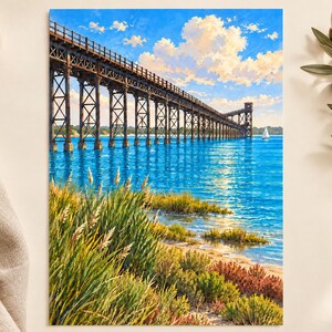 Peut inclure: Une impression d'art verticale repr&eacute;sentant un long pont &agrave; chevalets en bois brun fonc&eacute; s'&eacute;tendant sur une eau bleu vif. Le premier plan pr&eacute;sente des herbes c&ocirc;ti&egrave;res vertes et rouge&acirc;tres sur un rivage sablonneux sous un ciel bleu.