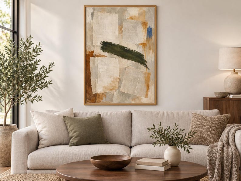 May include: A rectangular wall art piece in a light wood frame featuring an abstract composition. The artwork displays layered off-white rectangular shapes, warm ochre and brown tones, and a prominent, bold horizontal dark olive green brushstroke.