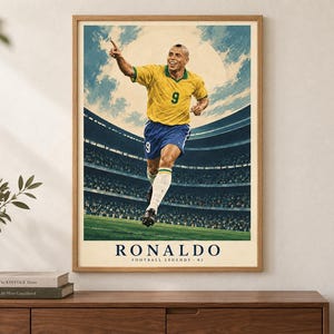 May include: A framed vertical poster featuring a stylized illustration of a soccer player wearing a yellow jersey with the number 9 and blue shorts, running on a field inside a stadium. The text RONALDO FOOTBALL LEGENDS 02 is printed at the bottom.