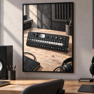 K&ouml;nnte beinhalten: Ein schwarzer tragbarer Synthesizer mit rechteckiger Oberfl&auml;che, zahlreichen runden Drehreglern, einem zentralen monochromen Display und einer Reihe wei&szlig;er und schwarzer Tasten, dargestellt als gerahmtes Wandbild auf einem Schreibtisch.