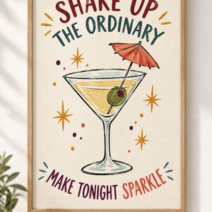 May include: A framed wall art print featuring a martini glass with a green olive and a red cocktail umbrella. The text reads SHAKE UP THE ORDINARY and MAKE TONIGHT SPARKLE in red, teal, and purple. The background is cream with yellow star accents.
