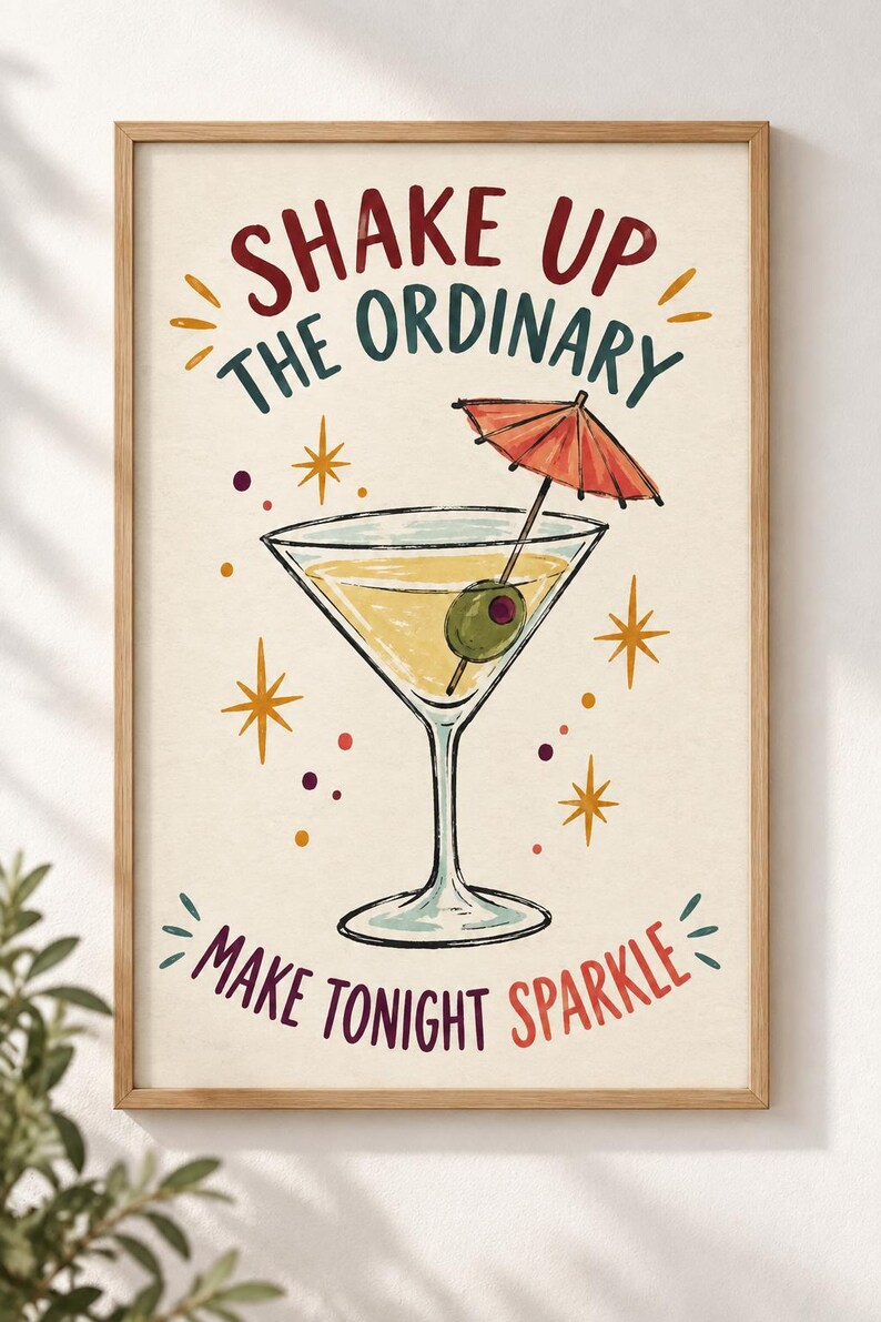May include: A framed wall art print featuring a martini glass with a green olive and a red cocktail umbrella. The text reads SHAKE UP THE ORDINARY and MAKE TONIGHT SPARKLE in red, teal, and purple. The background is cream with yellow star accents.
