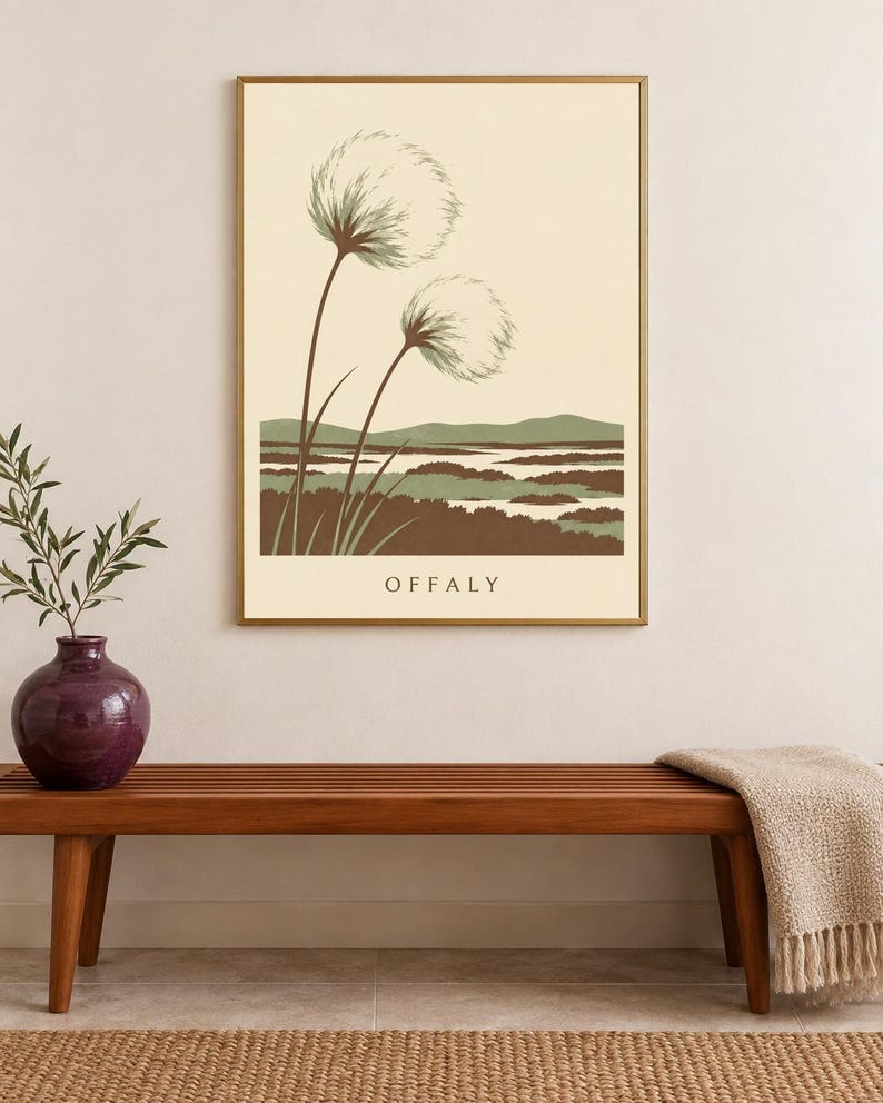 May include: A rectangular wall art print in a gold frame featuring a landscape illustration with two large, fluffy, dandelion-like seed heads in the foreground, green hills, and brown marshy terrain, with the word OFFALY printed at the bottom.