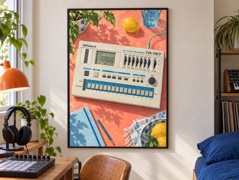 May include: A framed wall art print featuring a Roland TR-727 Rhythm Composer drum machine on a coral-coloured surface. The illustration includes a lemon, a blue glass of water, a blue notebook, a pencil, and a bowl of lemons, all under sunlight.