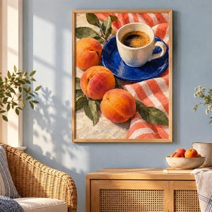 May include: A framed wall art print featuring a still life composition of three ripe orange peaches with green leaves resting on a red and white striped cloth next to a white ceramic coffee cup placed on a vibrant blue saucer.