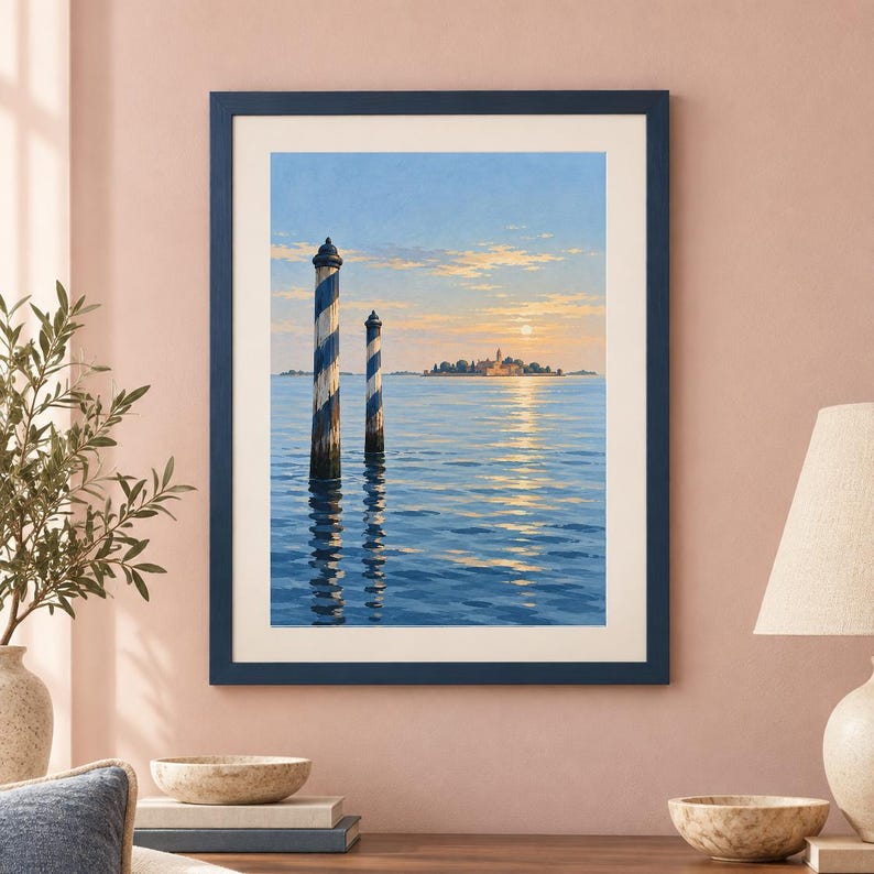 May include: A framed wall art print depicting a serene seascape with two blue and white striped wooden mooring poles in the foreground. The background features a distant island with buildings under a soft sunrise sky reflecting on the water.
