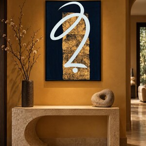 May include: A rectangular wall art piece featuring a dark navy blue background with a central vertical gold leaf panel and a large, fluid white calligraphic brushstroke shape that curves across the center, all enclosed in a thin black frame.
