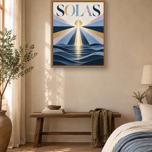 May include: A rectangular wall art print in a thin brown frame featuring the word SOLAS in large dark blue letters. The artwork depicts a stylized golden sun rising over dark blue ocean waves with radiating beams of light in shades of blue.