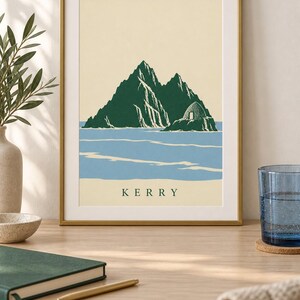 Pu&ograve; includere: Una stampa artistica incorniciata che presenta un'illustrazione stilizzata di un'isola rocciosa verde scuro con una piccola struttura in pietra, su un mare azzurro e uno sfondo color crema. La parola KERRY &egrave; stampata in verde scuro al centro.