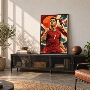 May include: A rectangular framed wall art print featuring a stylized illustration of a soccer player wearing a red jersey with the number 7. The artwork displays a large orange sun, a soccer ball, and dynamic red and blue graphic elements.