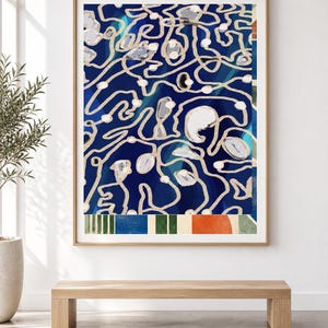 Puede incluir: Una impresi&oacute;n de arte mural rectangular enmarcada que presenta un fondo azul profundo con intrincados patrones de l&iacute;neas sinuosas de colores claros y formas circulares blancas dispersas. La secci&oacute;n inferior muestra una banda horizontal de rayas verticales en verde, azul, naranja y crema.