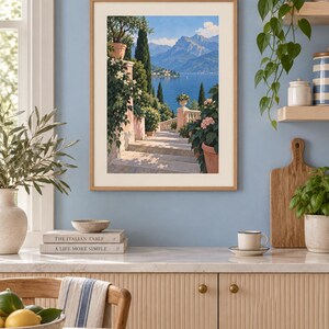 Peut inclure: Une impression d'art verticale encadr&eacute;e repr&eacute;sentant un escalier en pierre menant vers un lac bleu et des montagnes lointaines. La sc&egrave;ne pr&eacute;sente des pots en terre cuite avec des plantes vertes et des fleurs roses, dans un cadre en bois clair.