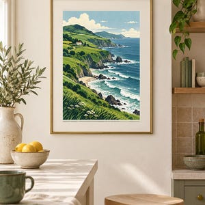 Pu&ograve; includere: Una stampa artistica paesaggistica incorniciata che raffigura una scena costiera con colline verdi, una piccola casa bianca su una scogliera, una spiaggia sabbiosa e onde blu intenso sotto un cielo limpido con nuvole, in una cornice dorata.