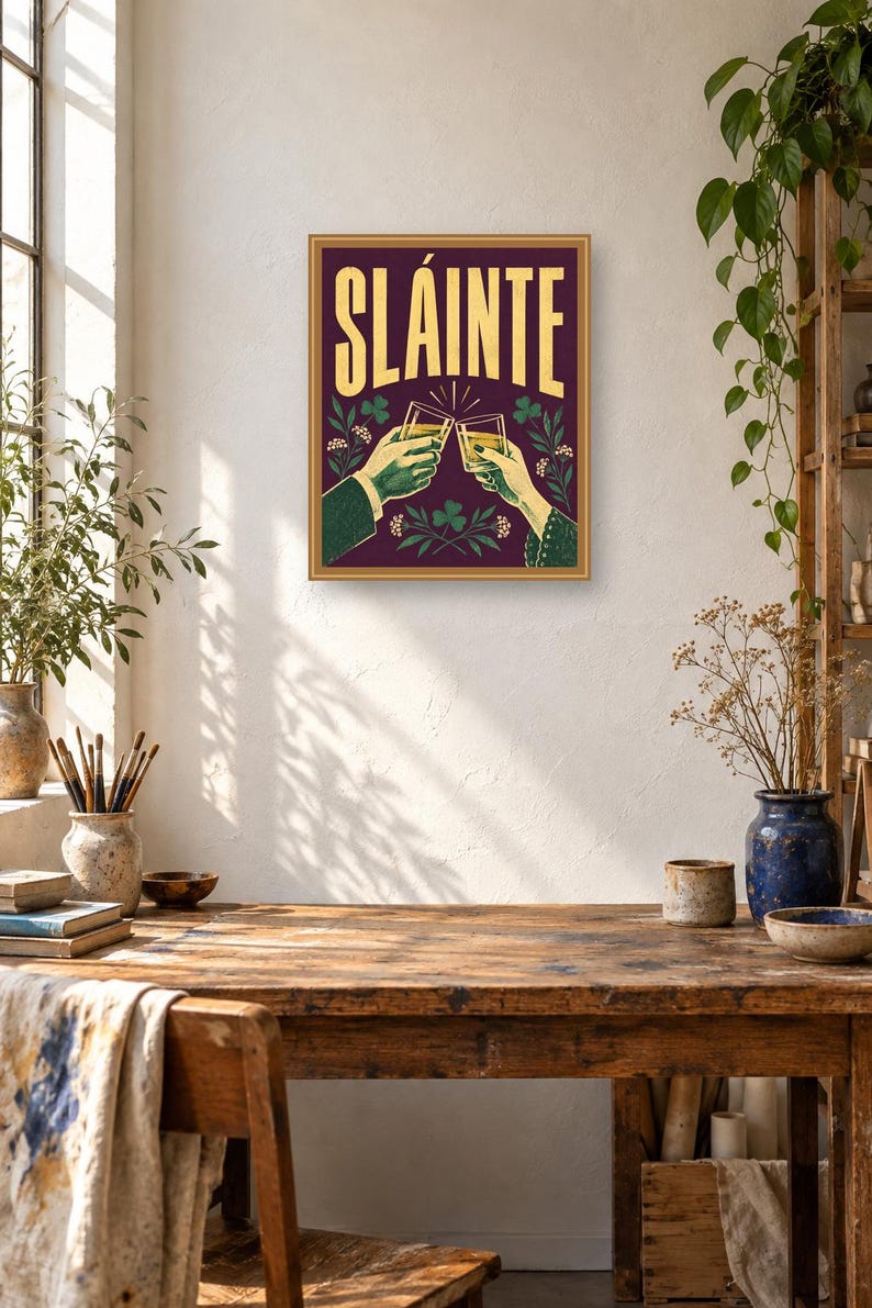 Pu&ograve; includere: Una stampa artistica da parete rettangolare con sfondo viola scuro e la parola SL&Aacute;INTE in grandi lettere gialle. L'illustrazione raffigura due mani che brindano con bicchieri pieni di un liquido dorato, circondate da motivi di trifogli e fiori verdi.