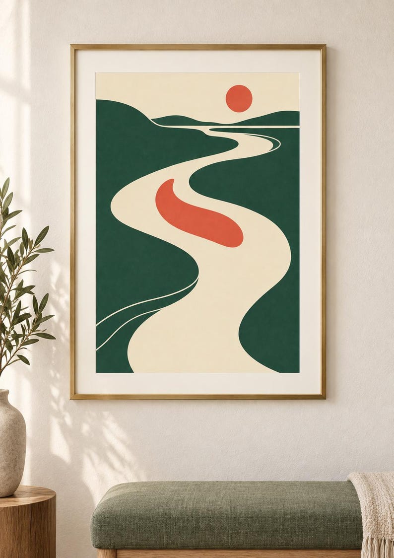 May include: A framed wall art print featuring a stylized landscape illustration with a winding cream-colored river, dark green rolling hills, a solid red sun, and a single red organic shape floating in the center of the river against a cream background.