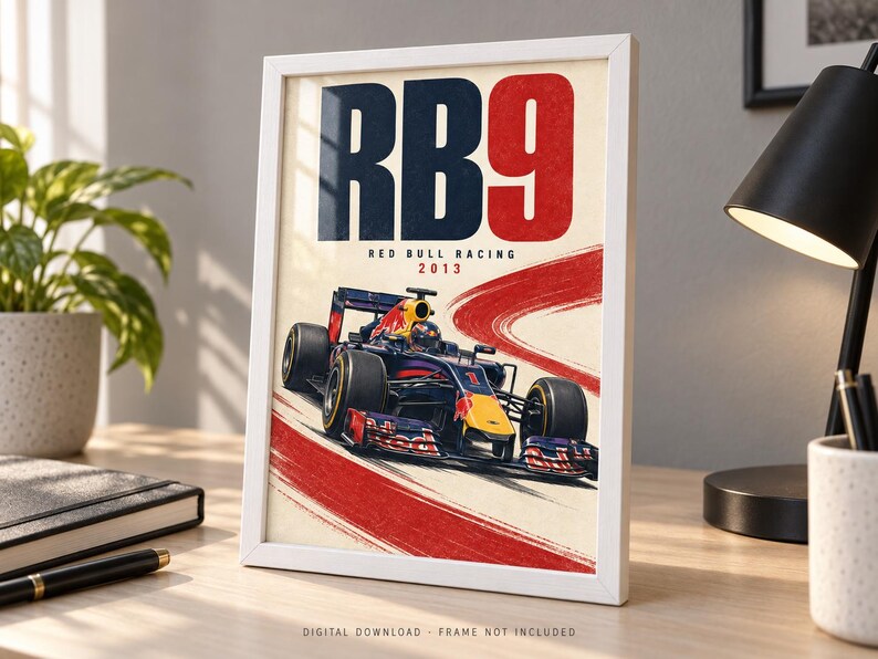 May include: A framed poster featuring a dark blue and red Formula 1 race car on a track. The text reads RB9, RED BULL RACING, and 2013. The design includes a bold red curved brushstroke across a cream background, showcasing the car in motion.