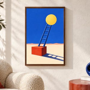 May include: A framed wall art print featuring a surreal landscape with a bright yellow circle suspended in a deep blue sky above a red cube. A blue ladder leans against the cube, which rests on a beige desert floor with a long, dark shadow.