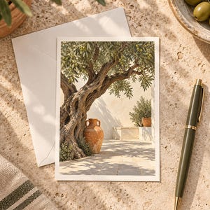 May include: A rectangular greeting card featuring a printed illustration of a gnarled olive tree with green leaves and small olives, a terracotta amphora, and a stone courtyard. The card is placed next to a matching envelope and a dark olive green pen.