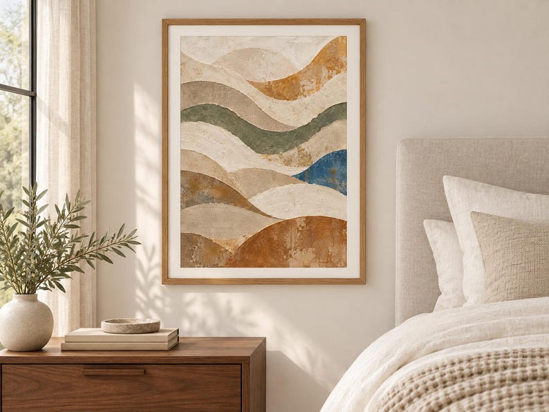 Pu&ograve; includere: Una stampa artistica da parete incorniciata che presenta una composizione paesaggistica astratta con forme curve stratificate in tonalit&agrave; terracotta, beige, verde salvia e un singolo accento blu intenso, in una cornice di legno chiaro.