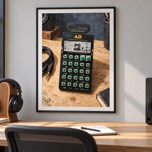 May include: A black pocket operator rhythm synthesizer featuring a digital LCD screen with a sewing machine icon, multiple square buttons with green accents, and two green rotary knobs. The device is labeled with the text rhythm and pocket operator.