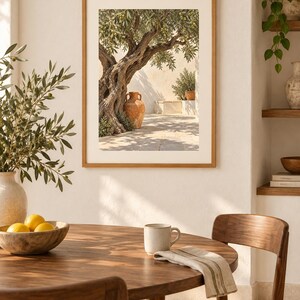 May include: A framed wall art print depicting an ancient olive tree with a large terracotta amphora resting at its base in a sunlit Mediterranean courtyard. The scene features textured stone walls, dappled shadows, and warm, earthy tones.