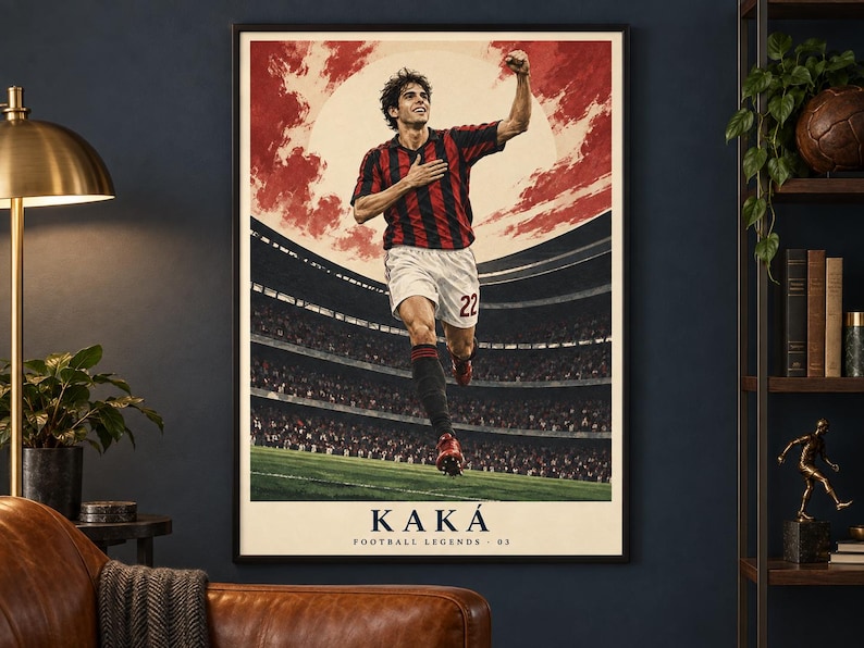 May include: A framed vertical poster featuring a soccer player in a red and black striped jersey and white shorts with the number 22, celebrating on a field. The background shows a stadium and a large sun. Text at the bottom reads KAK&Aacute; FOOTBALL LEGENDS - 03.