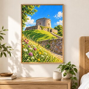 Puede incluir: Una impresi&oacute;n art&iacute;stica enmarcada que representa una torre de piedra sobre una colina cubierta de hierba bajo un cielo azul brillante. El primer plano muestra un prado vibrante lleno de margaritas blancas, tr&eacute;boles morados y flores.