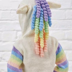 May include: A white knitted unicorn hoodie with a rainbow crocheted mane and tail. The hoodie has striped sleeves with pastel colors.