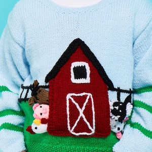 May include: A light blue knitted sweater with a red barn, green grass, and various animal appliques. The barn has a white door and window.