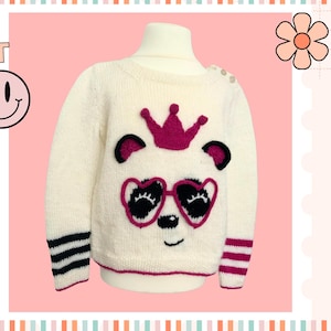 May include: White knitted sweater with a pink panda wearing a pink crown and sunglasses. The sweater has black and white stripes on the cuffs.